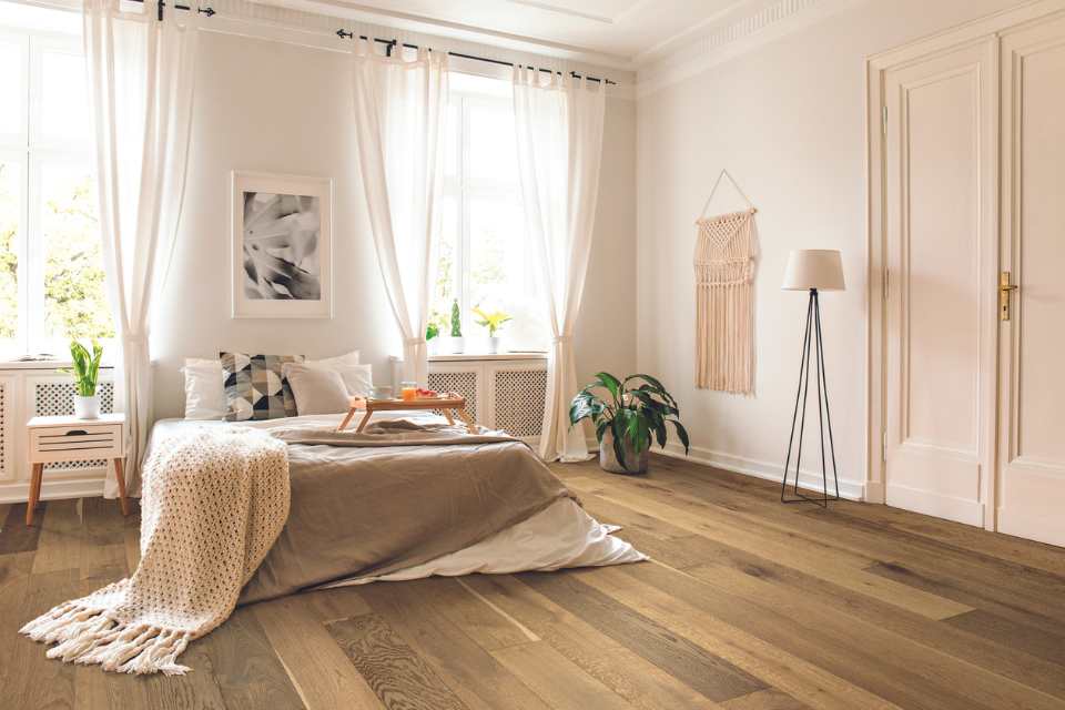 honey hued hardwood flooring in boho chic bedroom